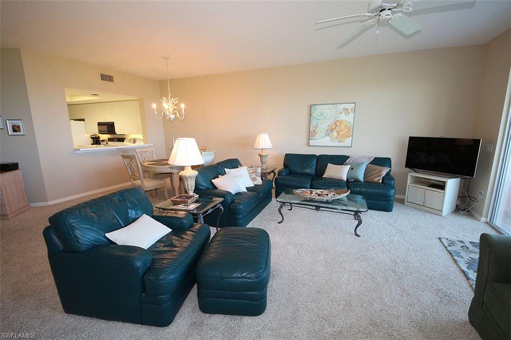 Living room with carpet flooring, a chandelier, and ceiling fan