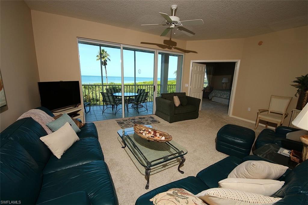 Carpeted living room with a textured ceiling and ceiling fan