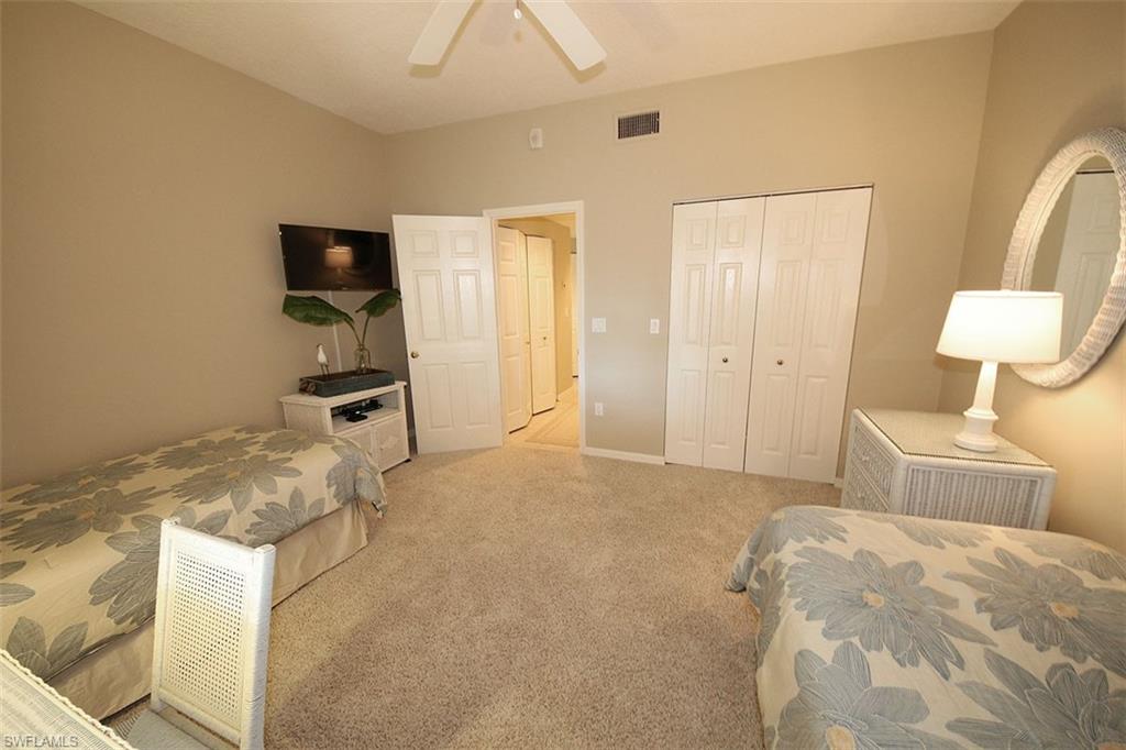 Carpeted bedroom featuring a closet and a ceiling fan