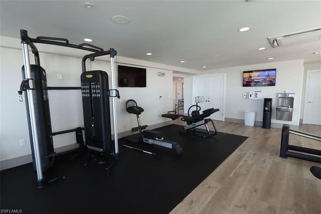 Workout room with recessed lighting, light wood-style flooring, and attic access