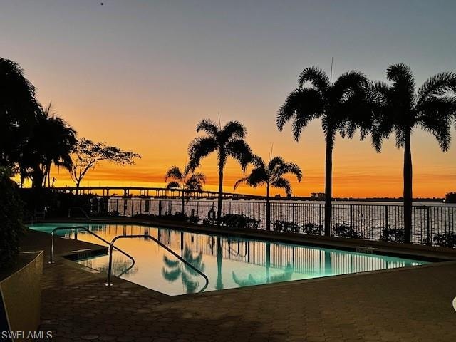 Pool at dusk featuring a community pool and a patio area