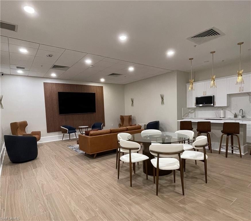 Community entertainment room with large screen TV, dining area & kitchen.