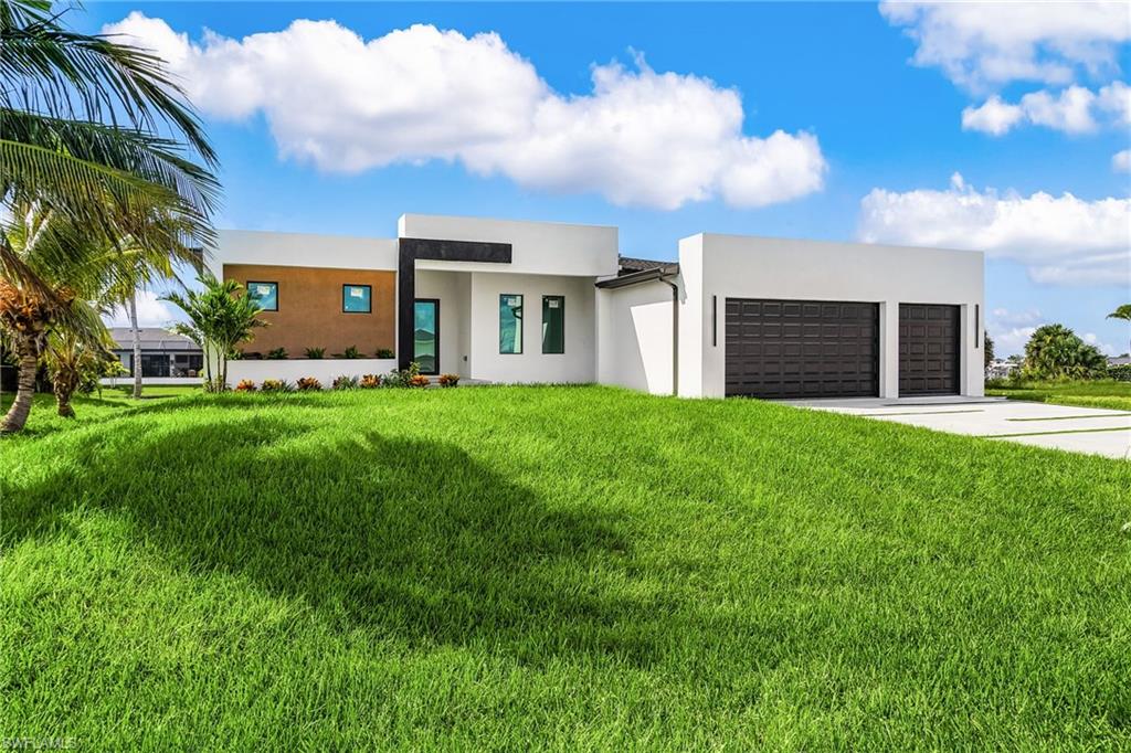 Modern home with stucco siding, driveway, a front yard, and an attached garage