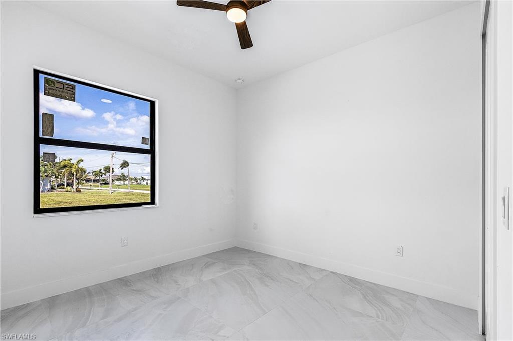 Spare room with a ceiling fan and baseboards