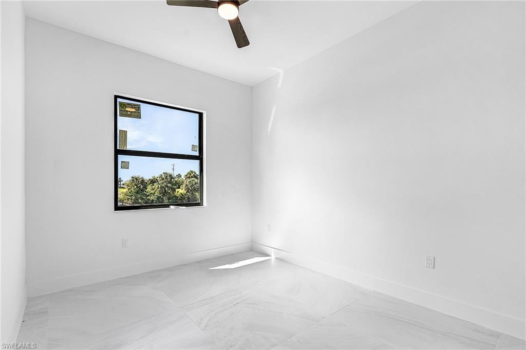 Empty room with a ceiling fan and baseboards