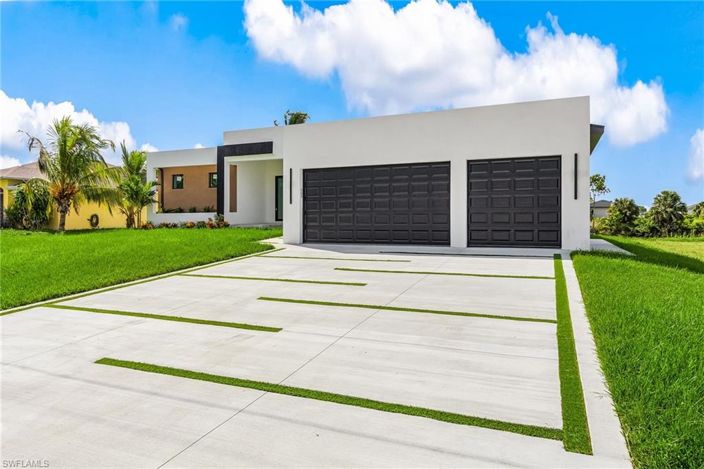 Contemporary home featuring concrete driveway, a front yard, stucco siding, and an attached garage