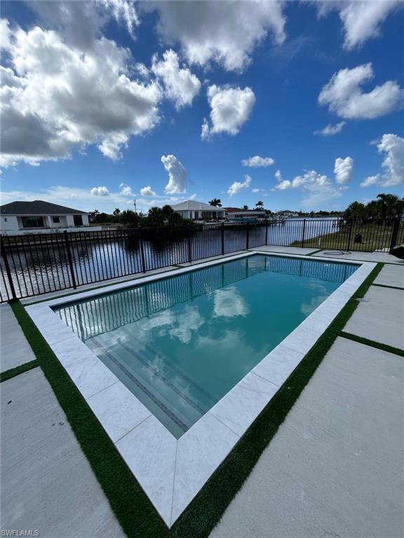 View of swimming pool featuring a water view and a patio area
