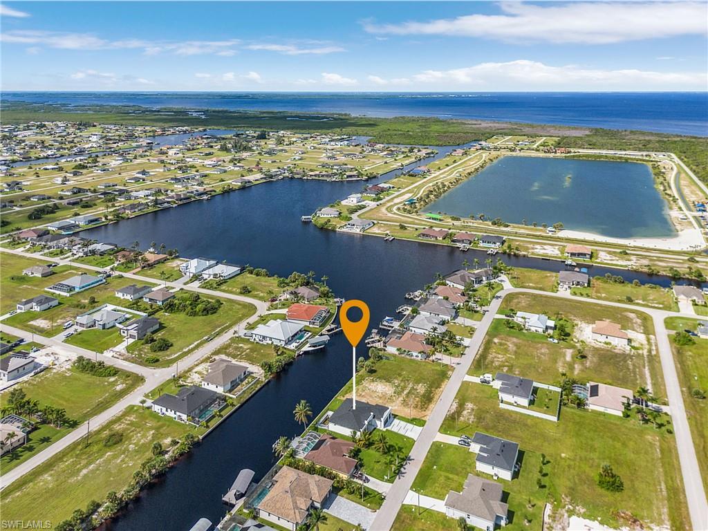 Aerial view of property and surrounding area featuring a nearby body of water and nearby suburban area