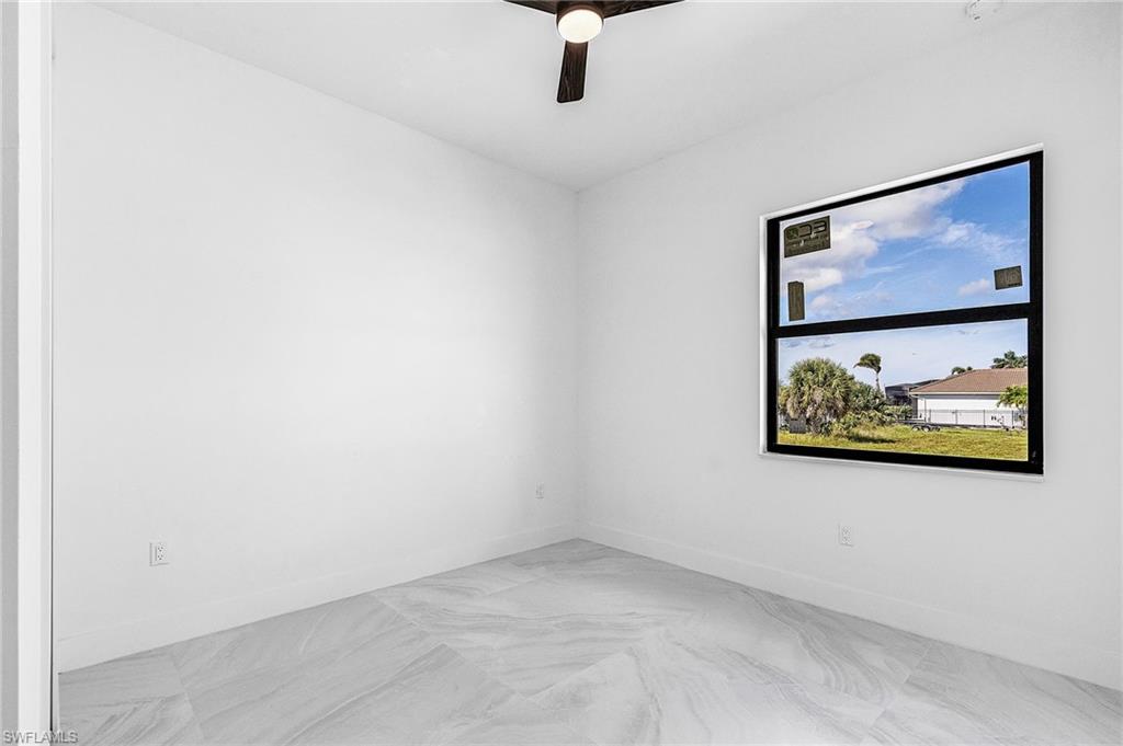 Unfurnished room with baseboards and a ceiling fan