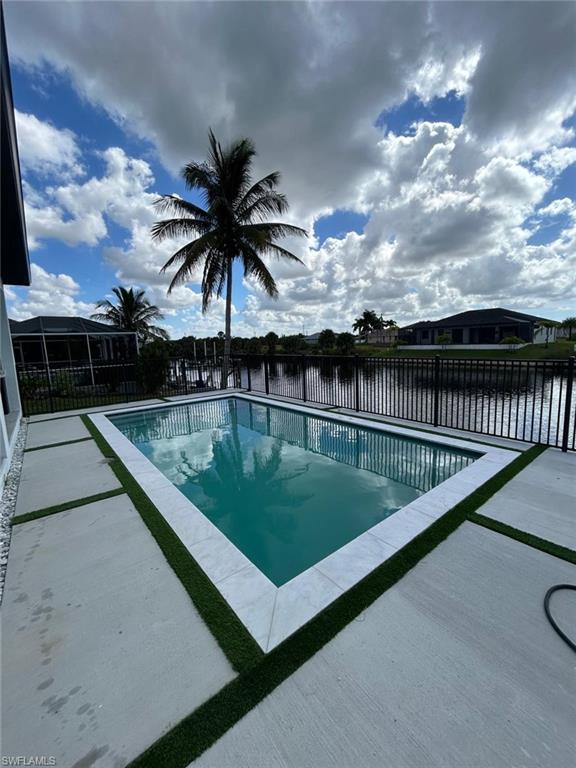 View of swimming pool with a water view, a patio area, and a sunroom