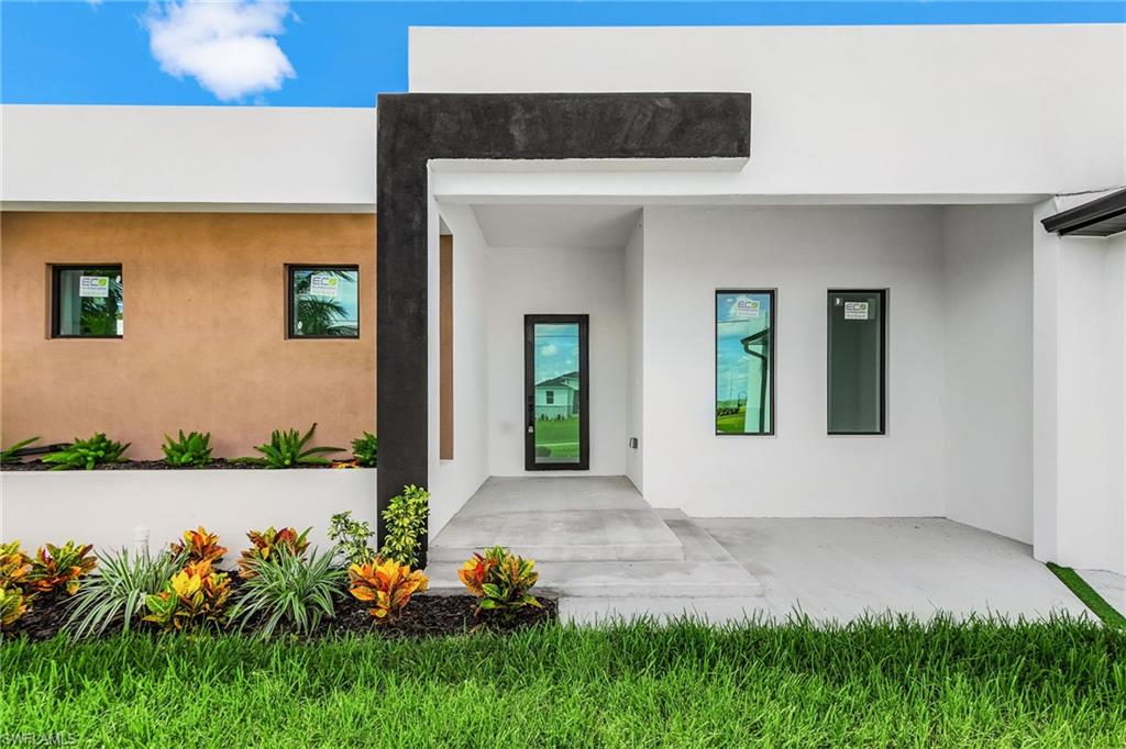 View of exterior entry with stucco siding and a patio
