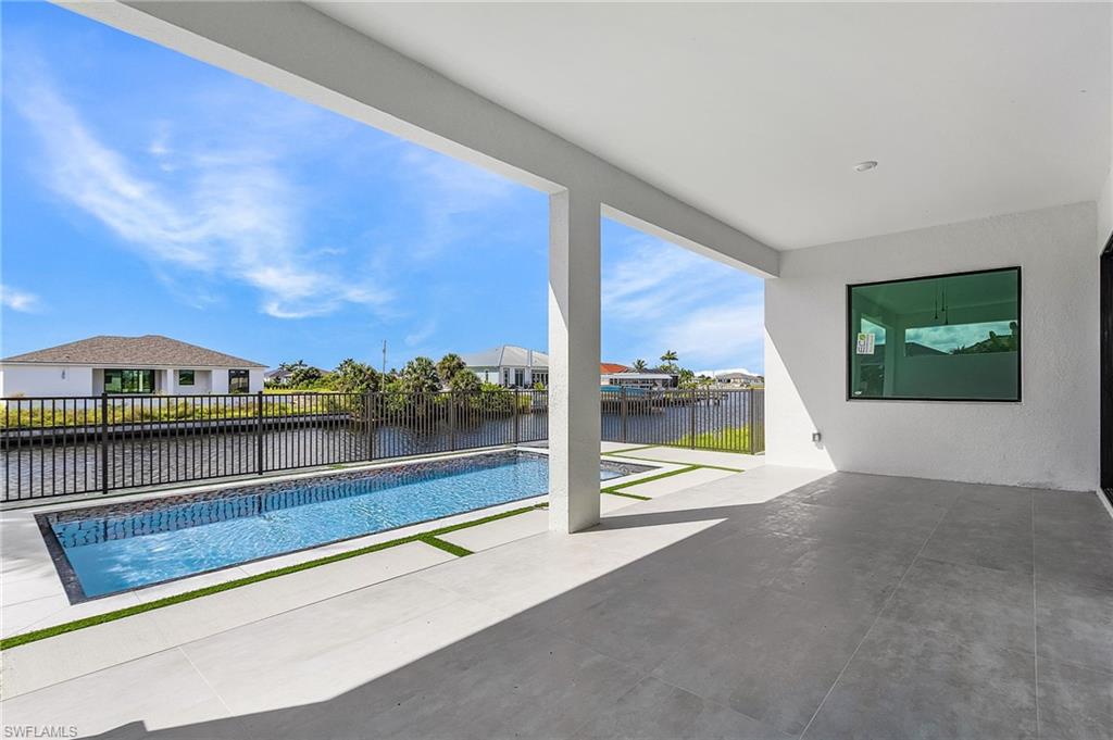 View of pool featuring a patio area, a water view, a fenced backyard, and a residential view