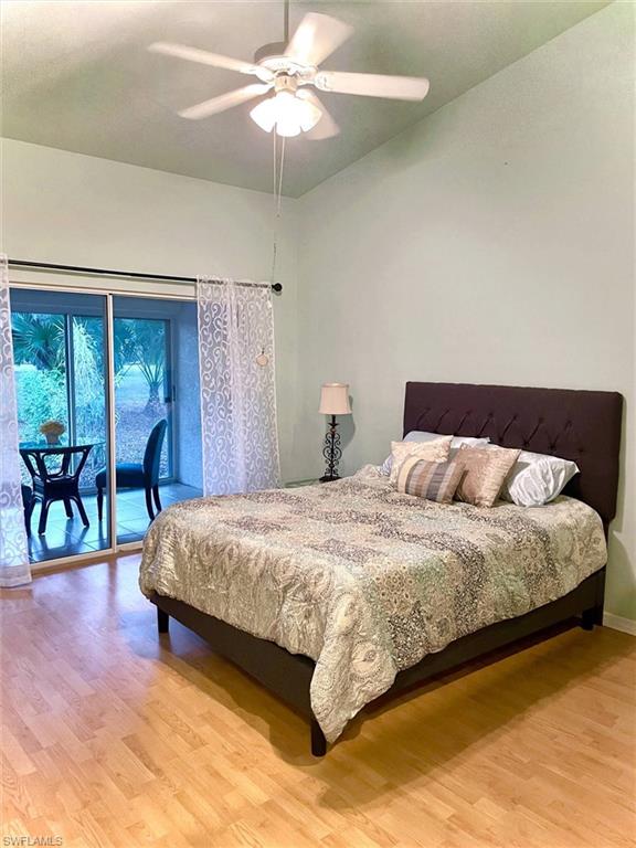 Room featuring light wood-finish flooring, a vaulted ceiling, and an overhead ceiling fan with lighting