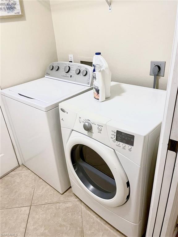 Dedicated laundry area featuring ceramic tile flooring and light-toned walls