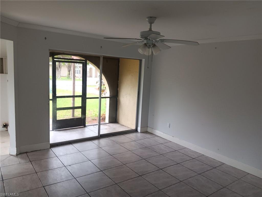 Empty room featuring ornamental molding, tile patterned floors, and ceiling fan