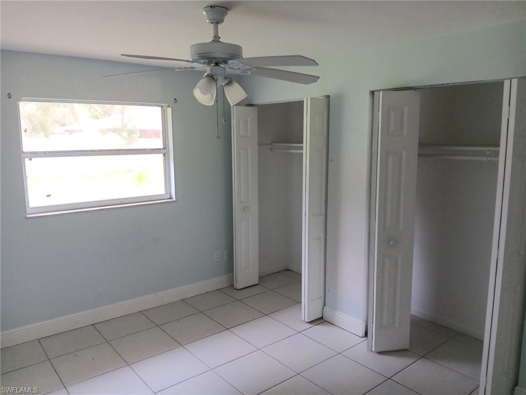 Unfurnished bedroom featuring two closets, light tile patterned flooring, and ceiling fan