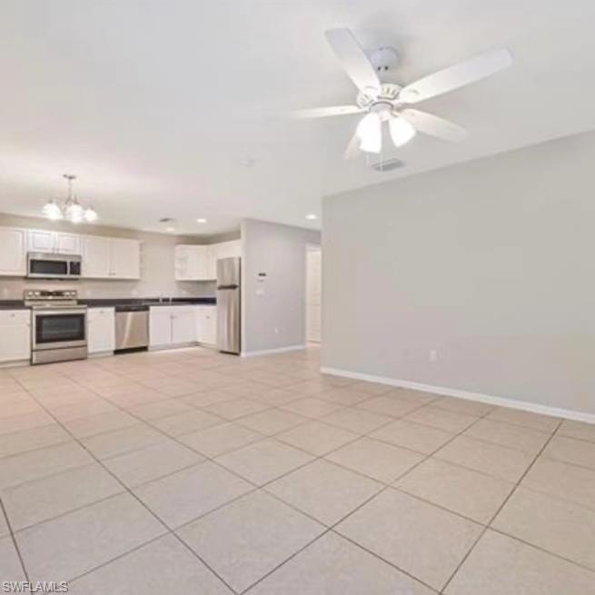Unfurnished living room featuring light tile patterned floors, a chandelier, recessed lighting, and a ceiling fan