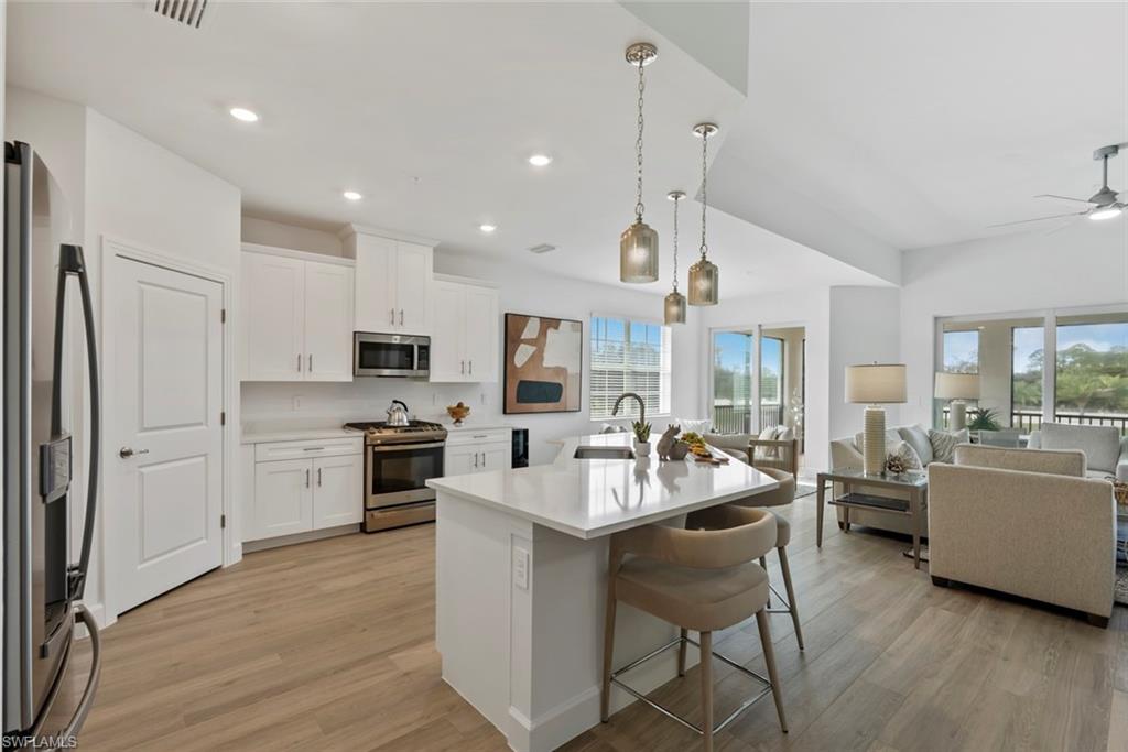 Kitchen featuring white cabinets, appliances with stainless steel finishes, a wealth of natural light, and sink