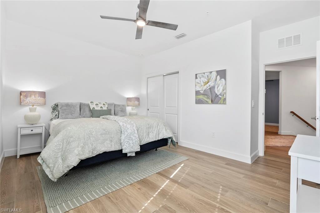 Bedroom with ceiling fan, light hardwood / wood-style floors, and a closet