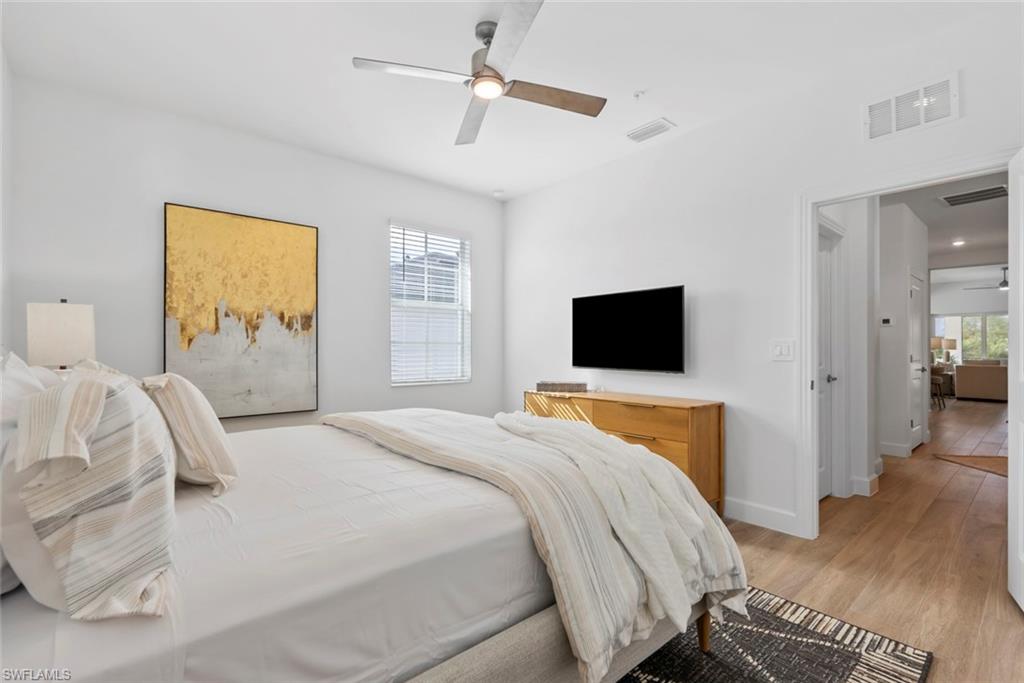 Bedroom with multiple windows, ceiling fan, and light hardwood / wood-style floors