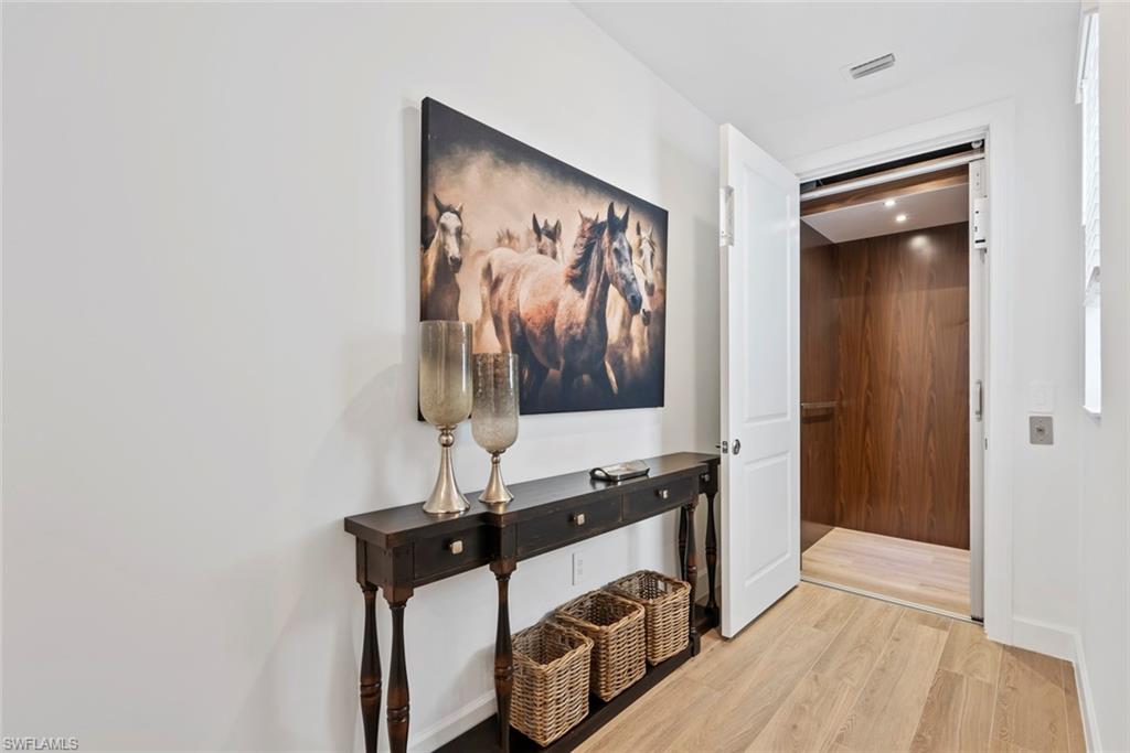 Hall with light hardwood / wood-style floors and elevator