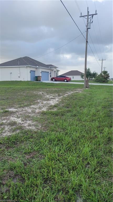 View of green lawn featuring an attached garage