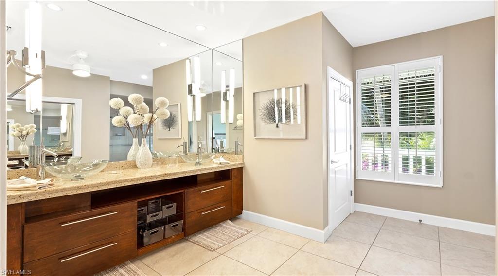 Full bath featuring double vanity, light tile patterned floors, and recessed lighting