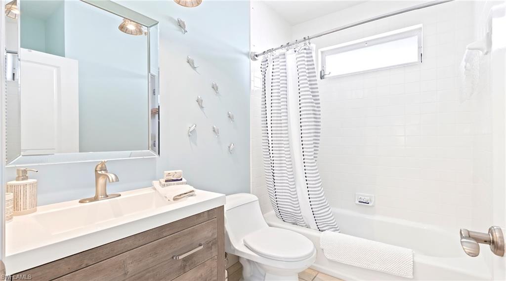 Bathroom with vanity and shower / bath combination with curtain
