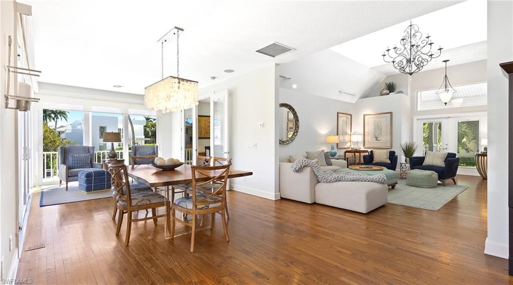 Dining area featuring suspended lighting, french doors, dark wood-style flooring, and vaulted ceiling