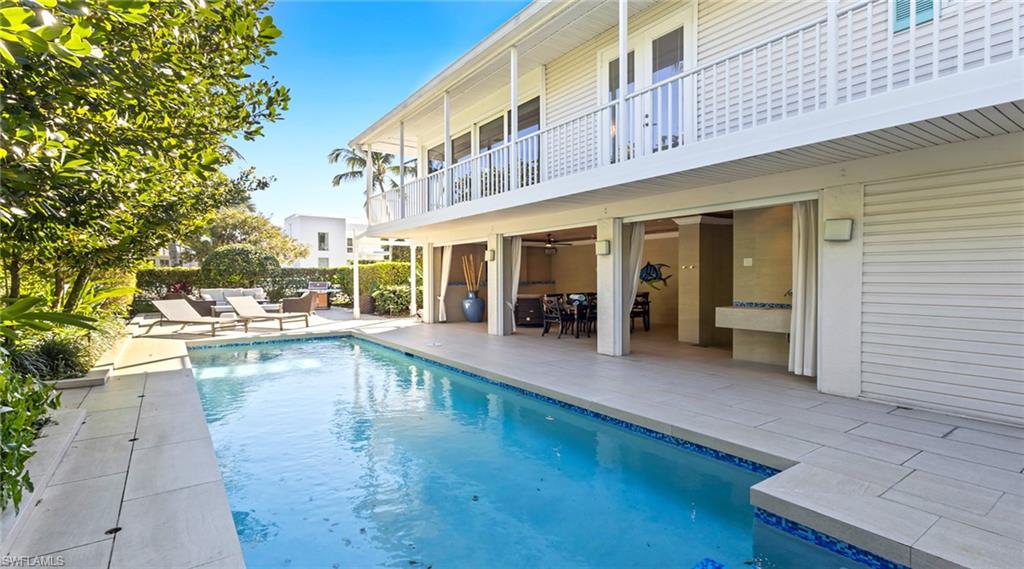 View of pool with patio surround and a balcony