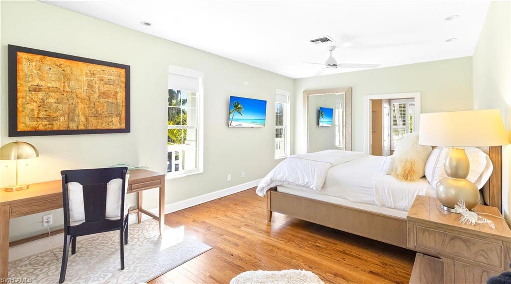 Bedroom with light wood-style floors, multiple windows, and ceiling fan