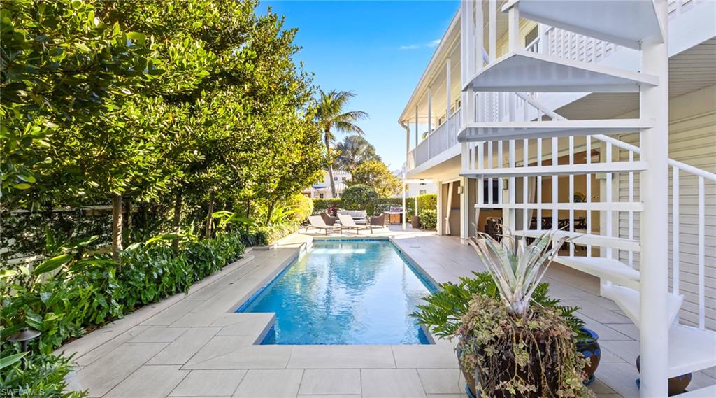 Outdoor pool featuring a patio and a balcony