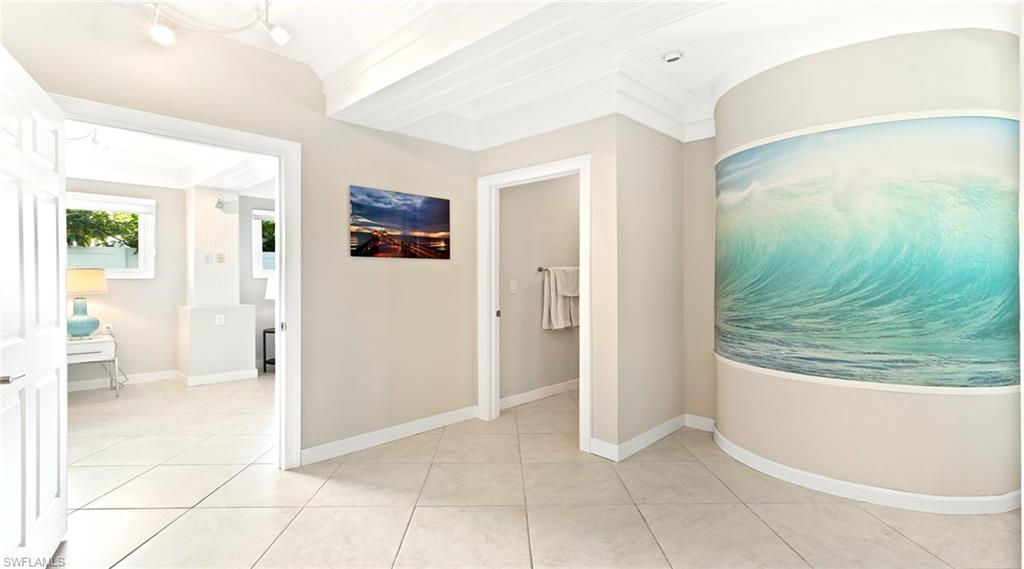 Corridor featuring crown molding and light tile patterned flooring