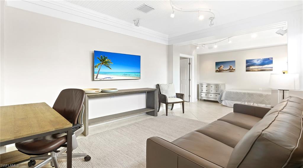 Office space with light tile patterned floors, crown molding, and rail lighting