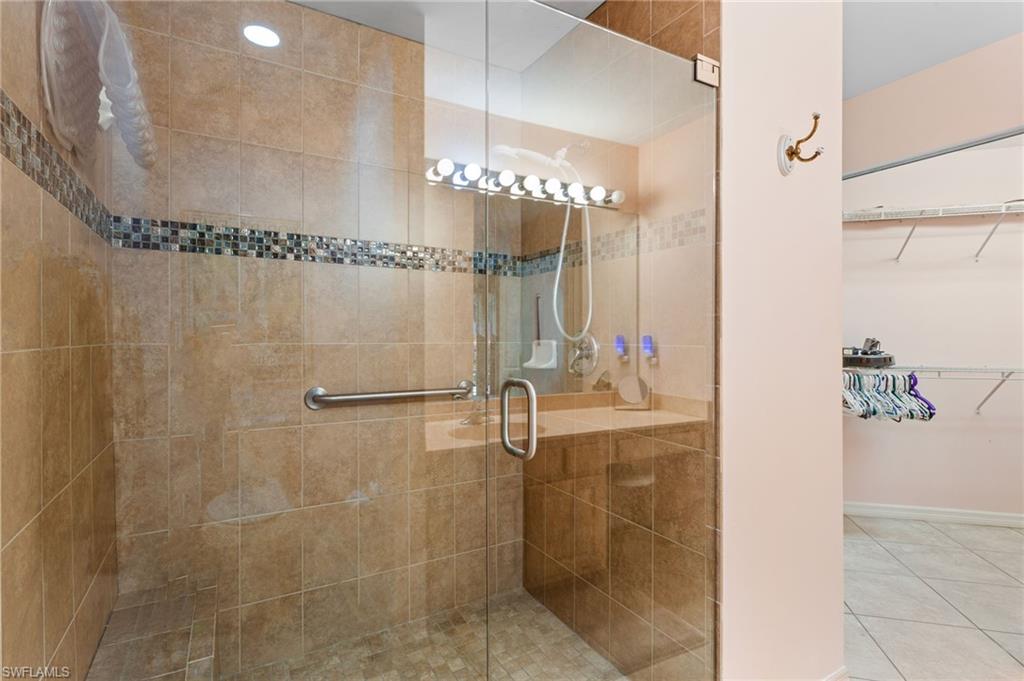 The first-floor primary bathroom has a large, beautifully tiled walk-in shower and extra-wide vanity. (This photo predates painting.)