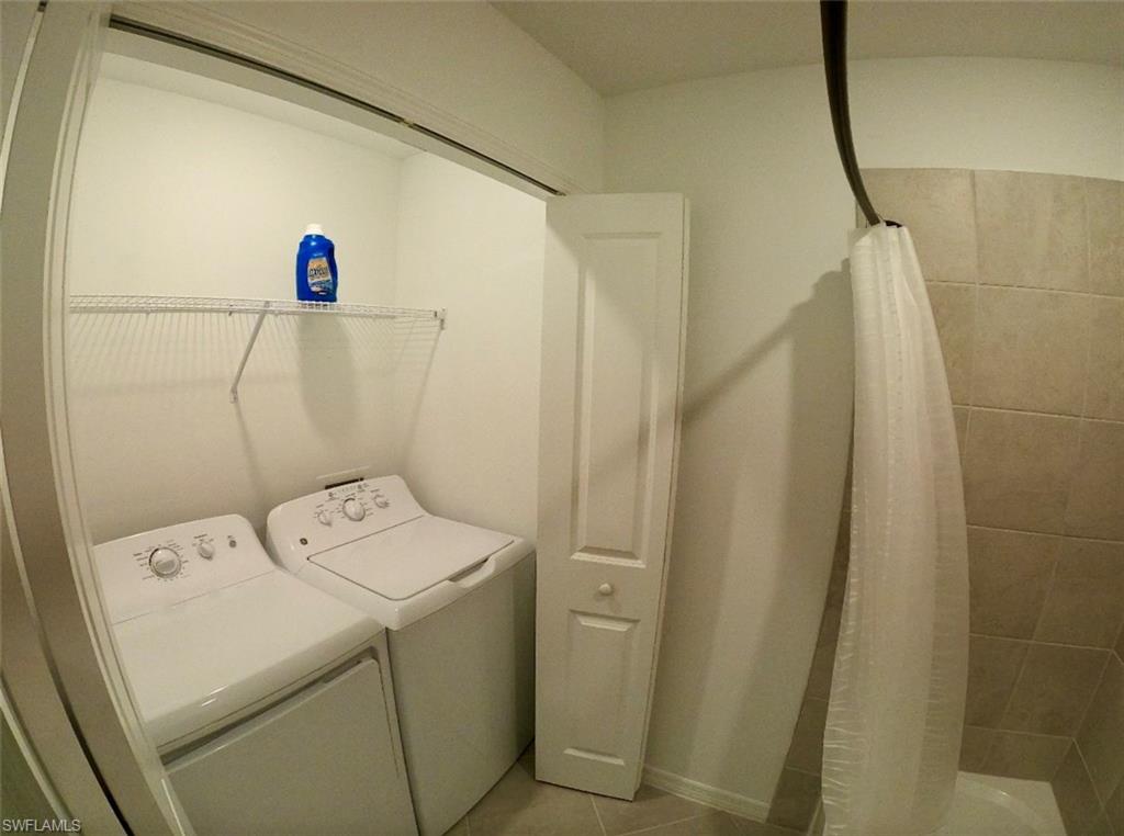 Laundry area with separate washer and dryer and tile patterned floors