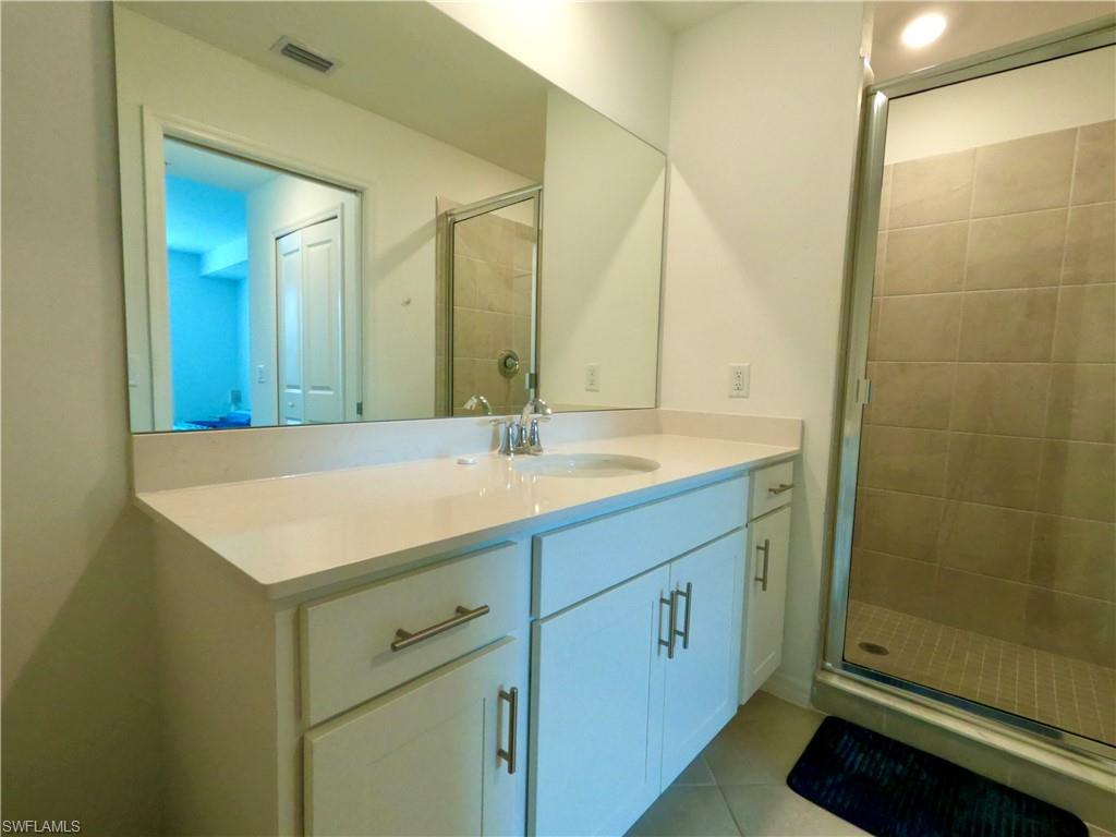 Full bath featuring vanity, a shower stall, and light tile patterned flooring