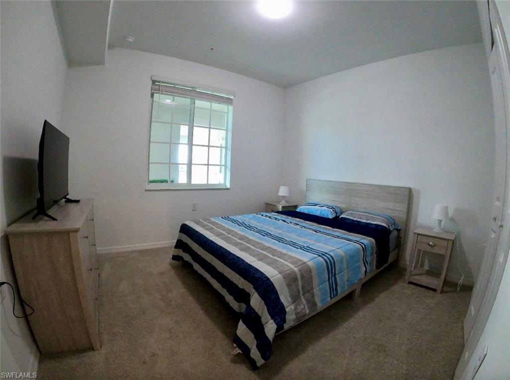 Bedroom with light carpet and a closet