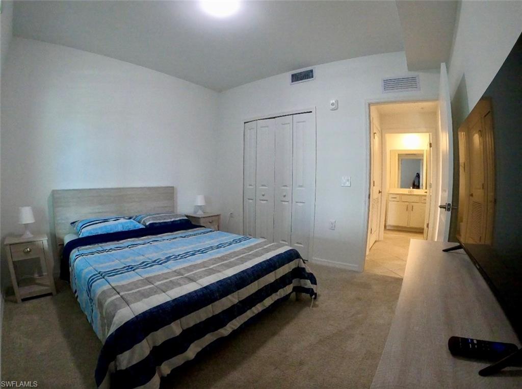 Bedroom featuring light carpet and a closet