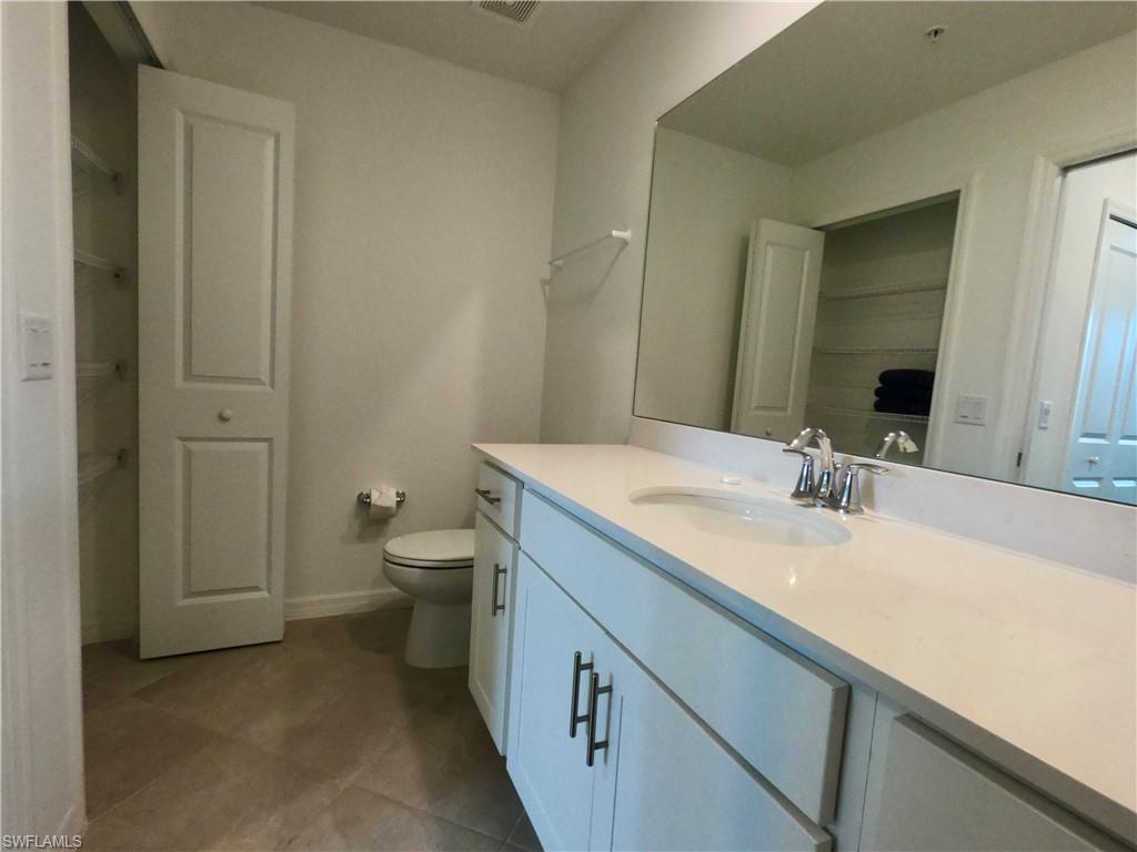 Full bathroom featuring vanity, a closet, and dark tile patterned floors
