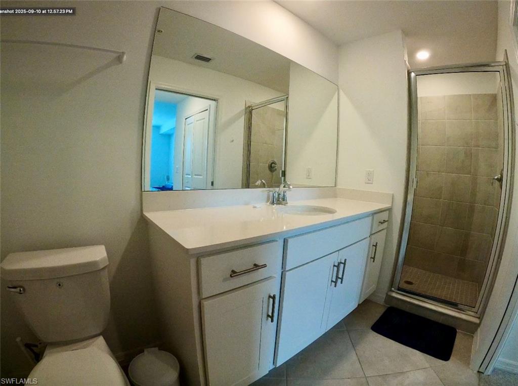 Full bathroom featuring light tile patterned floors, vanity, and a stall shower