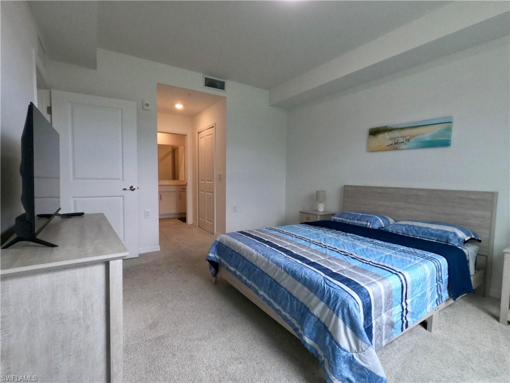 Bedroom featuring light carpet, ensuite bathroom, recessed lighting, and a closet