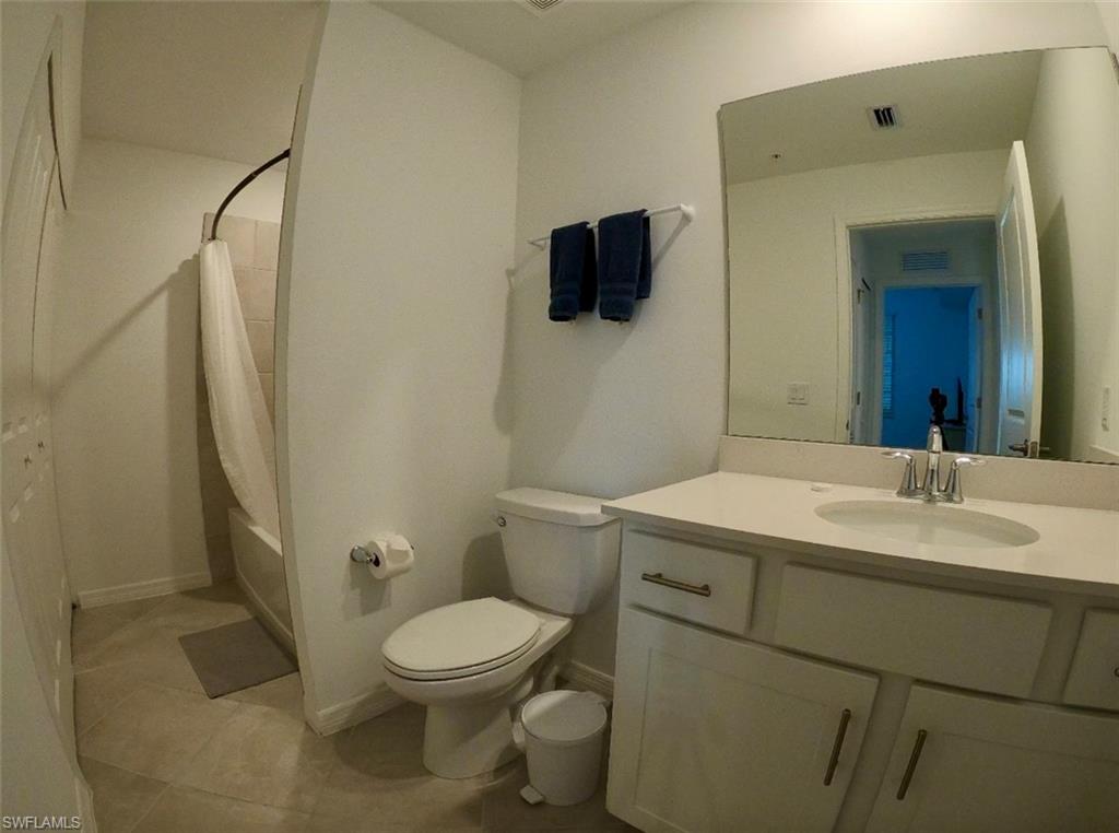 Bathroom featuring shower / bath combo, vanity, and light tile patterned floors