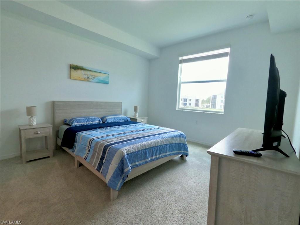 Bedroom featuring light carpet and baseboards