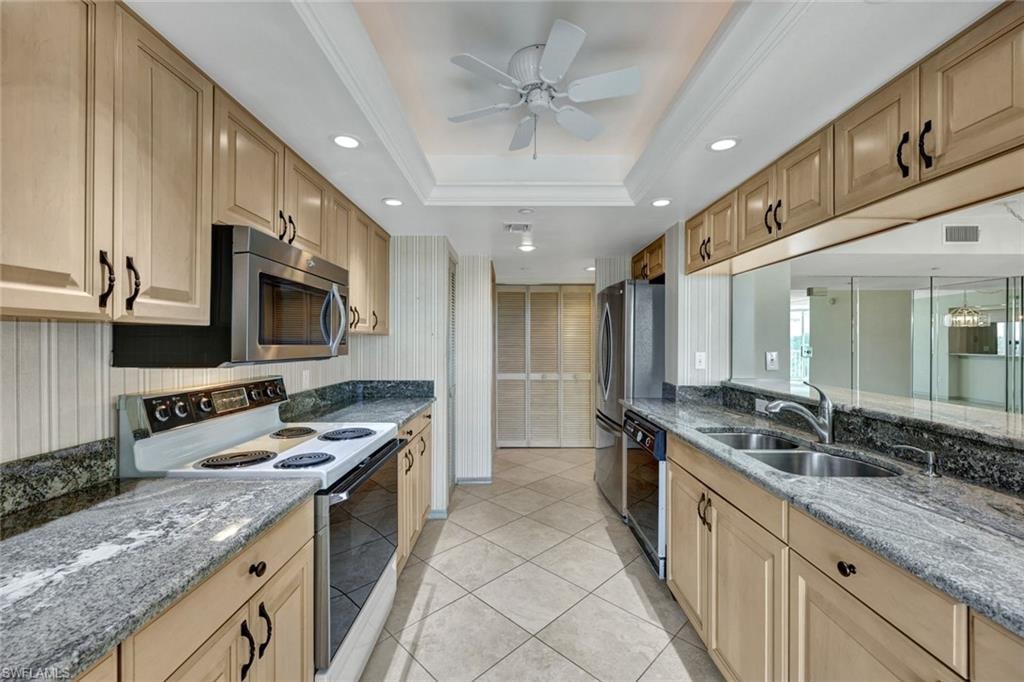 Kitchen featuring range with electric cooktop, dark stone counters, recessed lighting, light tile patterned floors, and black dishwasher
