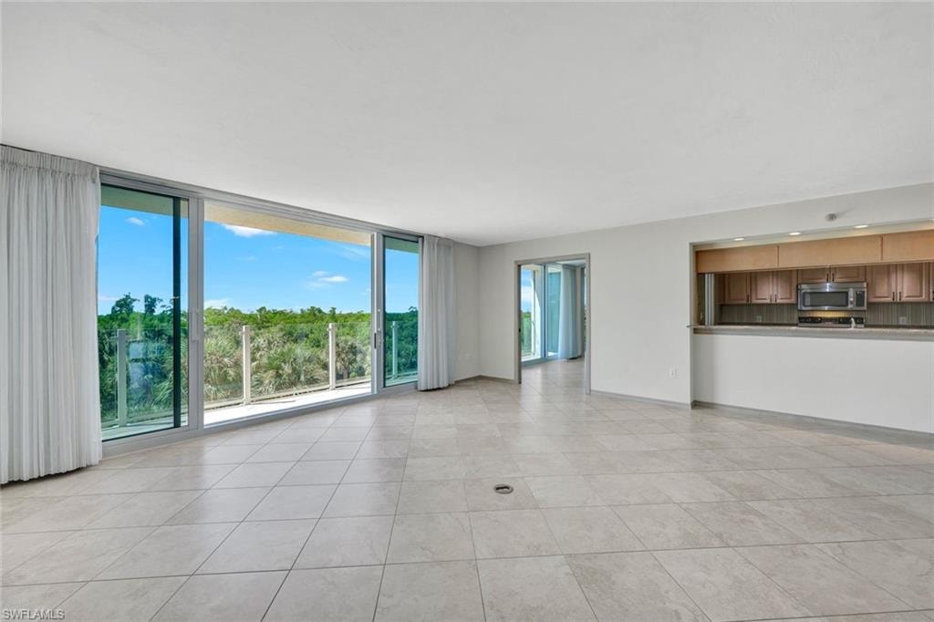 Unfurnished living room with expansive windows and light tile patterned flooring