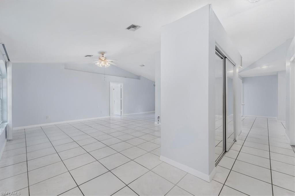Hallway featuring light tile patterned floors and baseboards