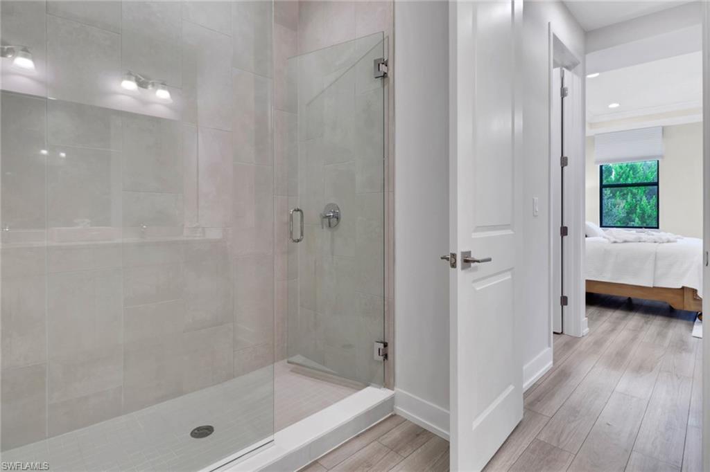 Ensuite bathroom with a stall shower, wood finished floors, and recessed lighting