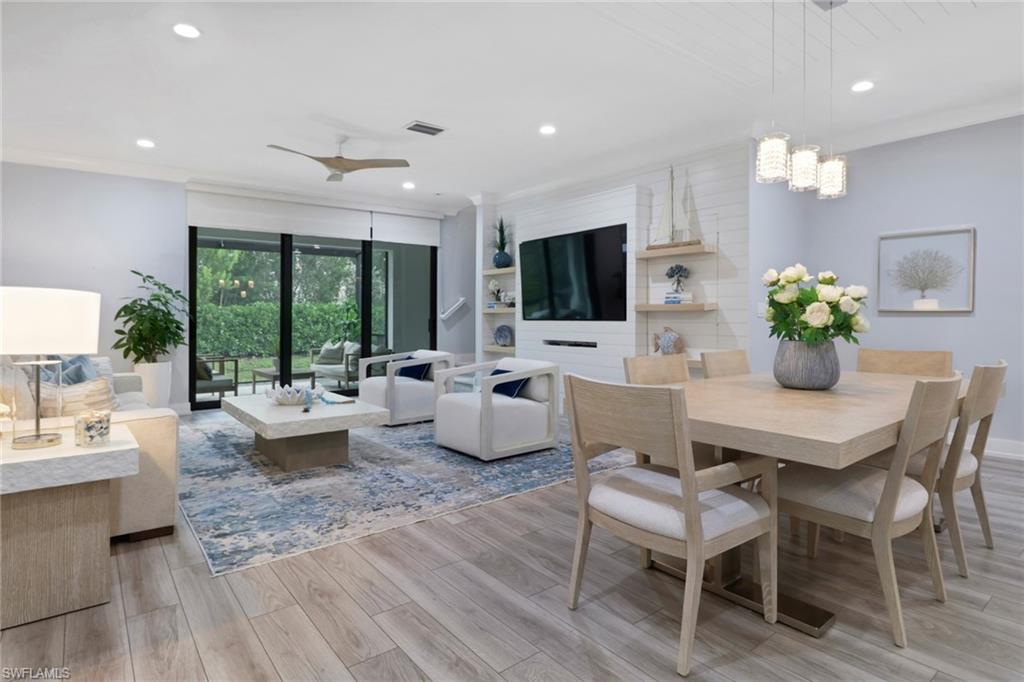 Dining room with recessed lighting, light wood-type flooring, crown molding, ceiling fan, and a chandelier