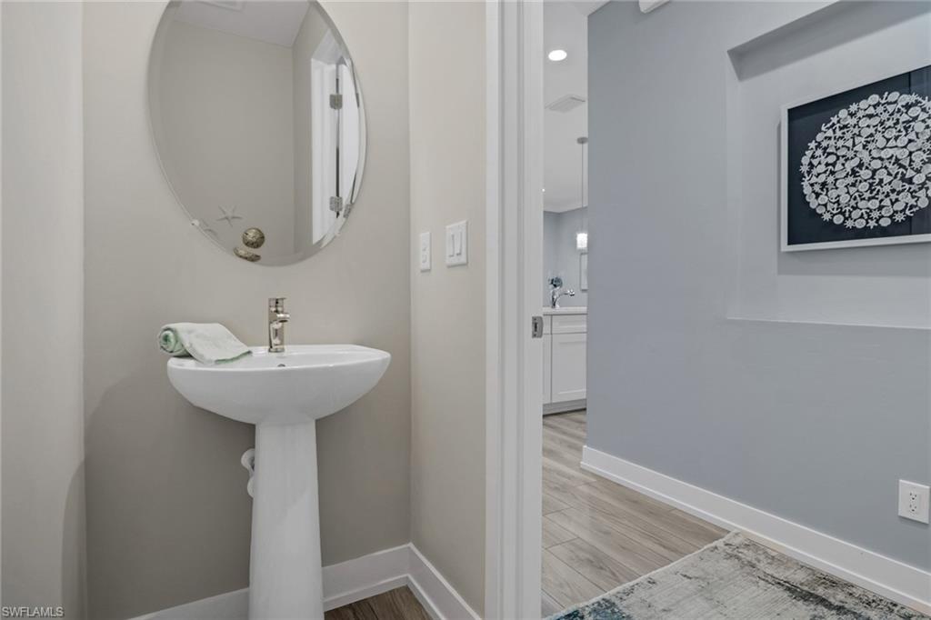 Half bath with baseboards and light wood-style floors